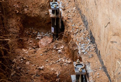 Foundation repair crew installing steel piers beneath a Florida home